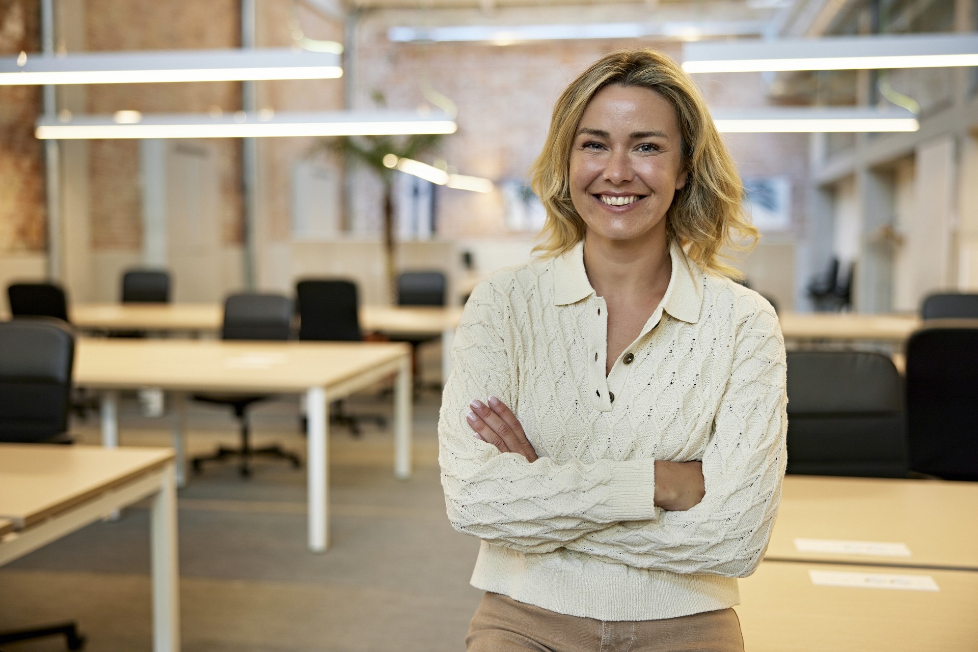 Vrouw zit op een bureau en verteld over de Wet Goed Verhuurderschap.